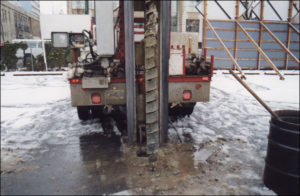 A drill rig placing a borehole enables observation of soil types beneath the surface, collection of soil samples, and installation of groundwater monitoring wells.